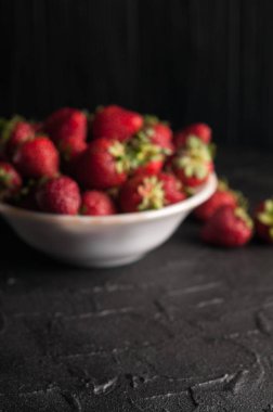 Siyah arka planda taze çilekler.