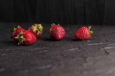 Siyah arka planda taze çilekler.