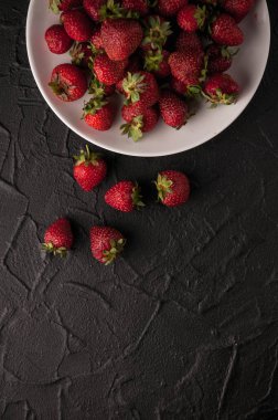 Siyah arka planda taze çilekler.