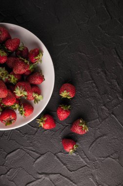 Siyah arka planda taze çilekler.