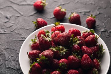 Siyah arka planda taze çilekler.