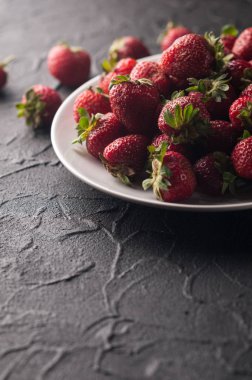 Siyah arka planda taze çilekler.