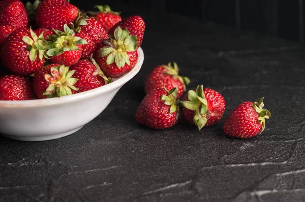 Siyah arka planda taze çilekler.