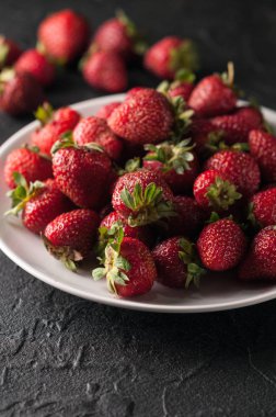 Siyah arka planda taze çilekler.