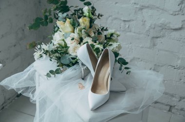 Beyaz gül buketi ve diğer çiçekler, Alyans üzerinde bir dışkı ile beyaz gelin Ayakkabı