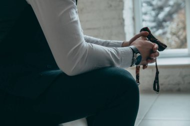 Patronun kırpılmış görüntüsü, el ele tutuşması, kelebeği elinde tutması, pahalı ve şık bir saat, ön manzara. Kavram