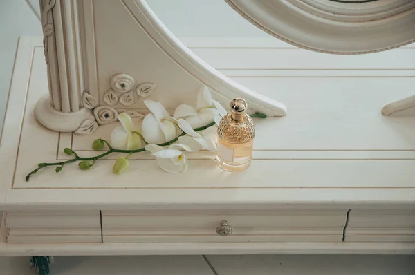 Flower bottle of perfume with white orchid, top shot