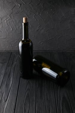 Şişe şarap üzüm ve peynir Camemberg siyah bir ahşap zemin üzerine.