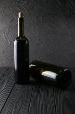 Şişe şarap üzüm ve peynir Camemberg siyah bir ahşap zemin üzerine.