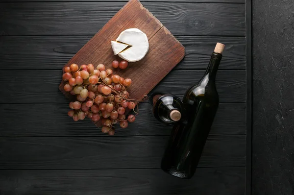 Garrafas Vinho Sobre Fundo Madeira Preta Com Uvas Queijo Camemberg — Fotografia de Stock