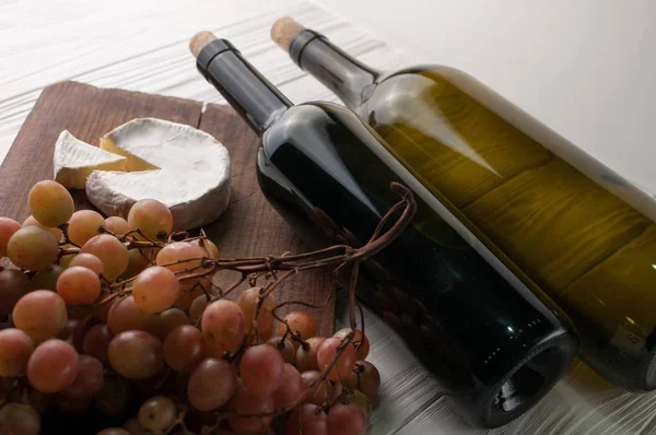 Garrafas Vinho Sobre Fundo Branco Madeira Com Uvas Queijo Camembert — Fotografia de Stock