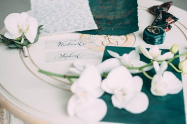 Düğün floristics ve ayrıntılar. Düğün davetiyeleri. Orkide. Yaka çiçeği damat için. Nikah yüzükleri. Kelebek