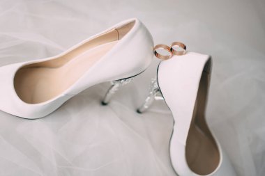 Bir çift bir tabure halkaları ile beyaz düğün ayakkabı.