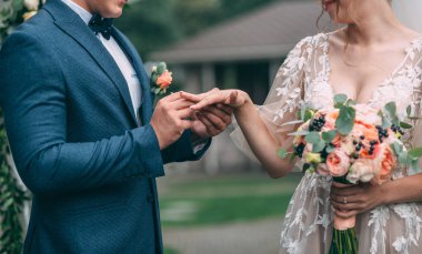 Nikah yüzükleri. Seçici odak. Yakın çekim. Damat geline nikah yüzüğü kum tören sırasında giyer..