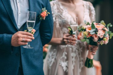 Gelin ve damat düğün gözlük tutun ve düğün kemer, kum töreni arka plan üzerinde durmak.