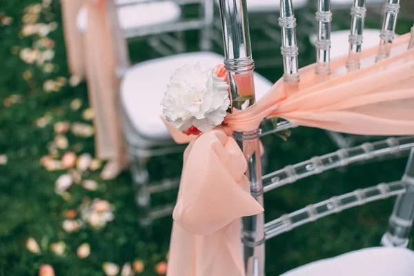 Cerimônia de casamento quadrado. Cadeiras transparentes são decoradas com flores, vegetação. Bonito, decoração svdebany na moda. Parte da decoração festiva, arranjo de flores . — Fotografia de Stock