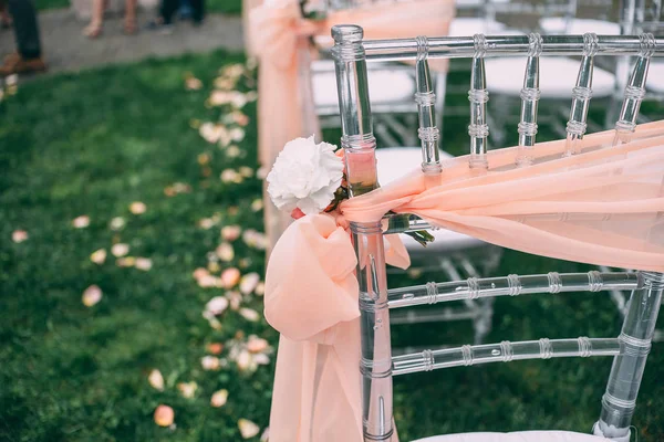 Cerimônia de casamento quadrado. Cadeiras transparentes são decoradas com flores, vegetação. Bonito, decoração svdebany na moda. Parte da decoração festiva, arranjo de flores . — Fotografia de Stock