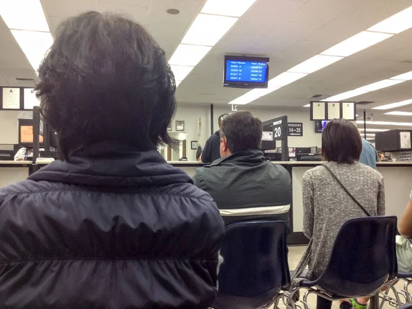 Департамент автотранспорту в Каліфорнії Люди чекають у переповненій кімнаті — стокове фото