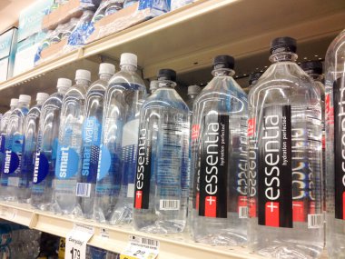 Süpermarkette kapaklı çeşitli plastik su şişeleri.