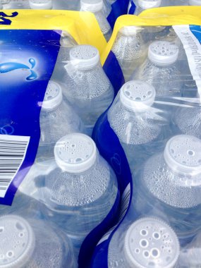 Süpermarkette kapaklı plastik su şişeleri.