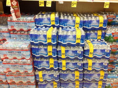 Süpermarkette kapaklı çeşitli plastik su şişeleri.