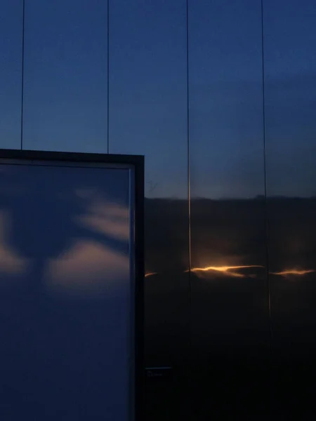 Edificio moderno reflejando nubes al atardecer —  Fotos de Stock