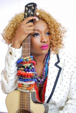Funk Afrikalı Model Ettiene Eko Couture ve gitar kıvırcık saçlı, kolye bileziği takan bir büstiyer.