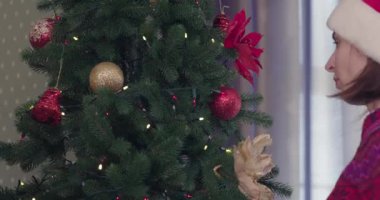 Noel ağacı. Kız ağaçta Noel topları giyiyor. Noel dekorasyonu. Noel evi dekorasyon iki kız. 