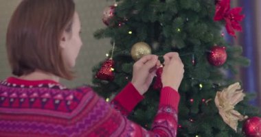 Noel ağacı. Esmer kız ağaçta Noel topları giyiyor. Noel dekorasyonu. Noel evi dekorasyon iki kız. 