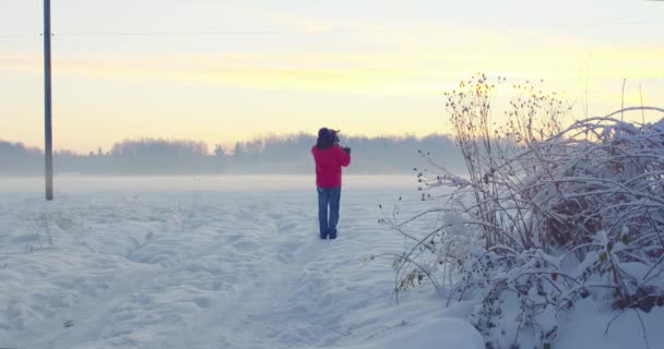 雪原乌克兰在冬季 橙色和粉红色的天空 带相机的人 — 图库视频影像