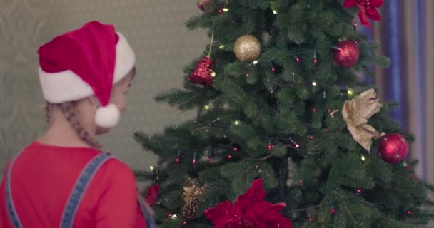 クリスマスツリー木の上にクリスマスボールを着ている二人の姉妹 クリスマスの飾りクリスマスハウスを飾る2人の女の子 — ストック動画