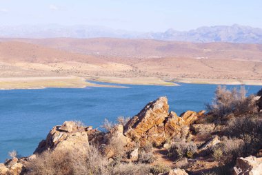 Mavi gölü olan çöl manzarası.