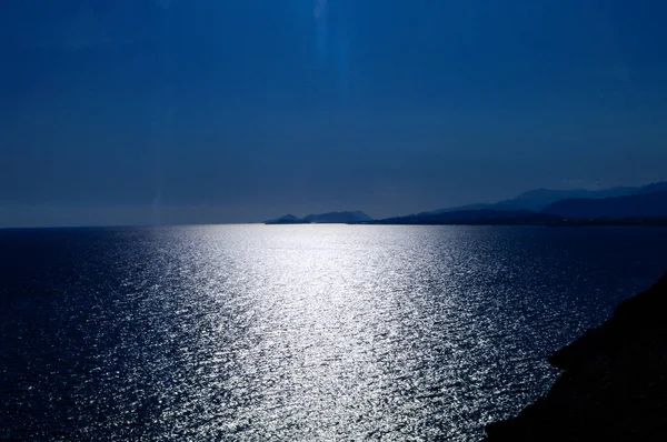 Moonlit path in the sea against a dark blue sky. — Stock Photo, Image