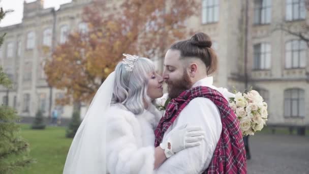 Um casal sueco feliz casados olhando um para o outro na frente de um castelo velho — Vídeo de Stock