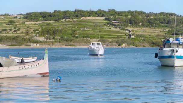 Barco colorido de ojos tradicionales Luzzu flotando en el puerto del pueblo pesquero mediterráneo Marsaxlokk, Malta — Vídeo de stock