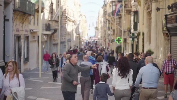 Uma multidão de turistas caminhando ao longo da rua República de Valletta, Malta — Vídeo de Stock