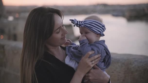 En fotosession av en mamma och hennes fem månader gammal baby nära havet kusten — Stockvideo