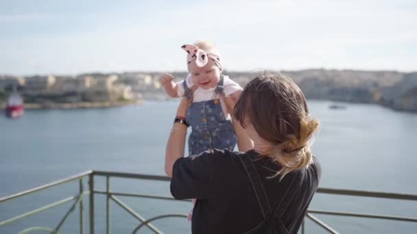 A photoshoot of a woman with a little baby near the sea on Malta in slowmotion — Stock Video
