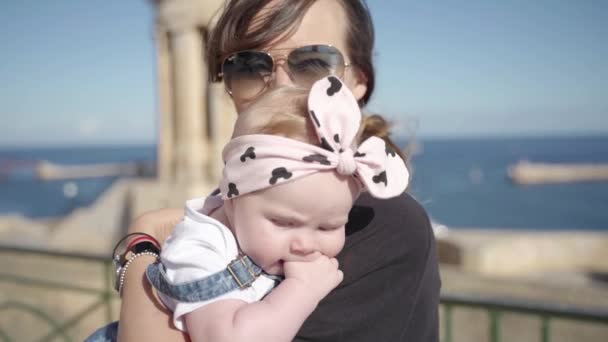 Una foto di una giovane madre e del suo bambino vicino al mare — Video Stock