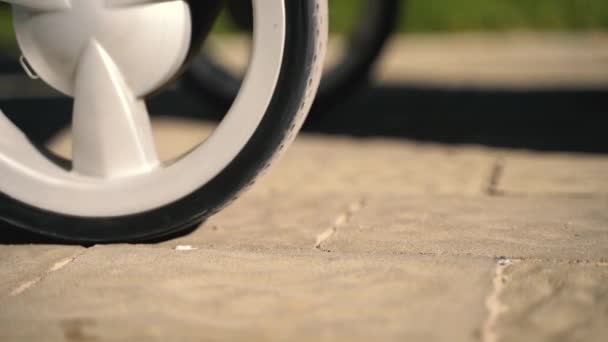 アスファルトの上の赤ちゃんのベビーカーの車輪のクローズ アップ計画 — ストック動画