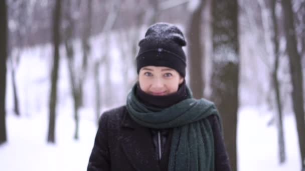 En mellersta plan av en kvinna i en svart varm kappa på en fotosession i en vinter forrest — Stockvideo
