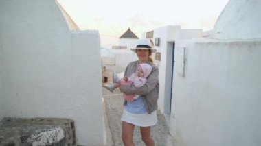 bir çocuk ile güzel kız Santorini güzel beyaz sokaklarında yürüyor