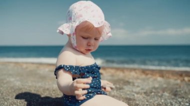 Deniz arka planda oturan bir yıllık kız yakın çekim planı