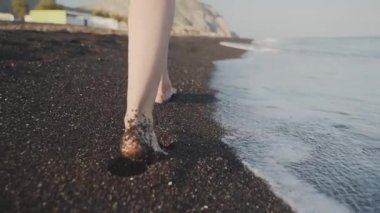 Deniz boyunca yürüyen bir kadın bacaklarının yakın çekim planı