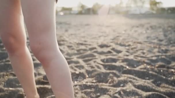Eine Mutter hält ein Baby im Tragetuch am Strand — Stockvideo