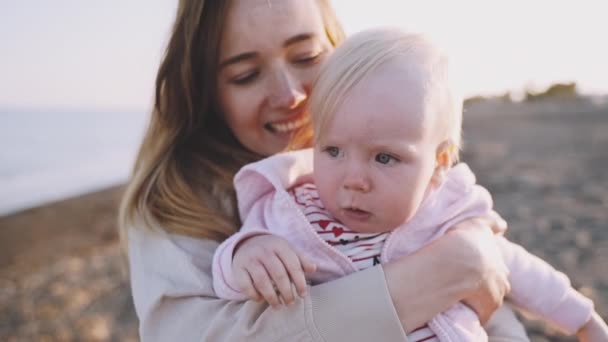 Egy közeli terv egy komoly baba anyja kezét a strandon — Stock videók