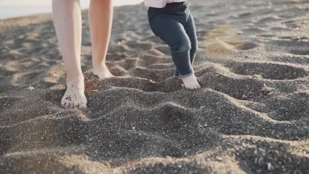 Une petite fille essaie de faire ses premiers pas le long de la côte de la mer sur Santorin — Video