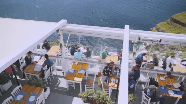 Turister som har lunch på en terrass bredvid stranden i Grekland. — Stockvideo