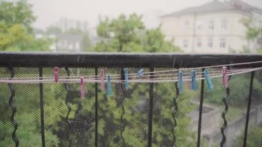Bazı renkli clothespins dökülen yağmurun yıkama hattına asmak. Yavaş hareket