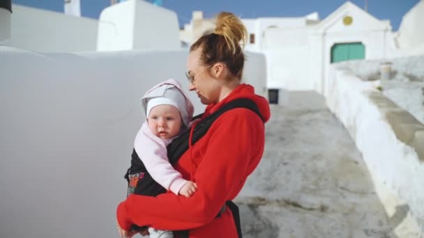 Gelukkige moeder en baby dochter in Sling Walking Street op zonnige dag — Stockvideo